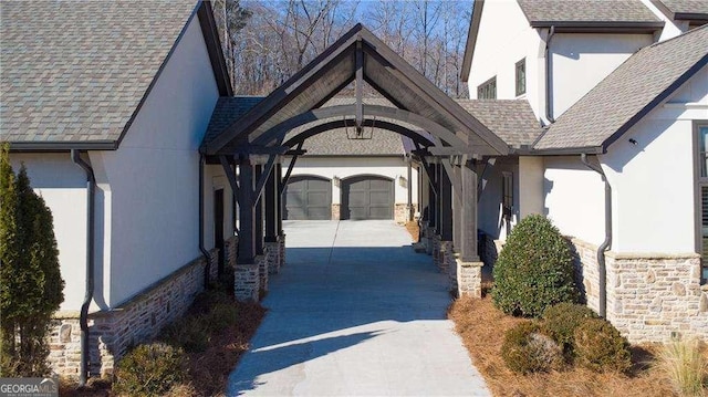 5152 Boulder Bluff Way, Suwanee, GA 30024 - property entrance featuring stucco siding, concrete driveway, stone siding, a shingled roof, and an attached garage