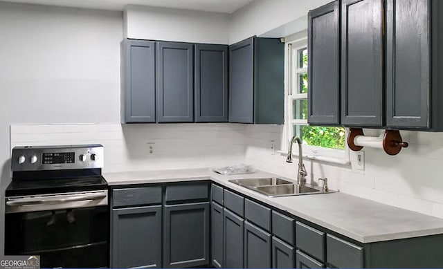 kitchen featuring sink, gray cabinetry, electric range oven, a healthy amount of sunlight, and decorative backsplash