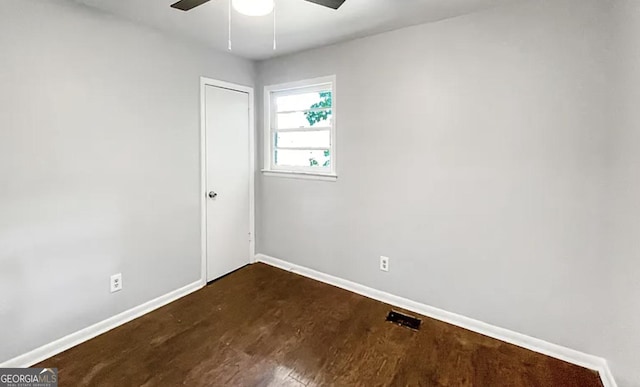 empty room featuring dark hardwood / wood-style flooring and ceiling fan