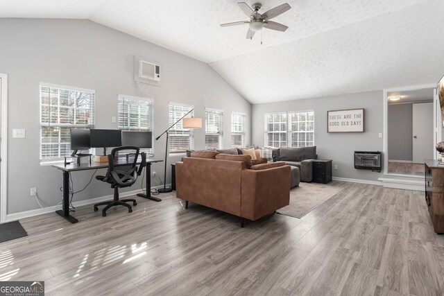 living room featuring lofted ceiling, light wood-type flooring, ceiling fan, a textured ceiling, and a wall unit AC