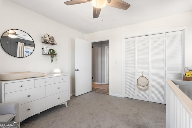 bedroom with light carpet, baseboards, a ceiling fan, and a closet