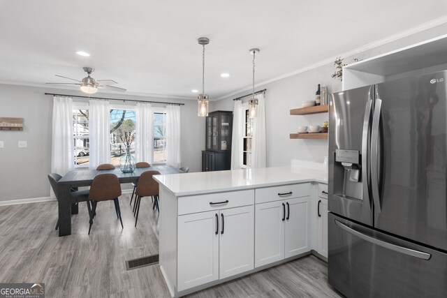 kitchen with white cabinetry, stainless steel range with gas stovetop, decorative light fixtures, and tasteful backsplash