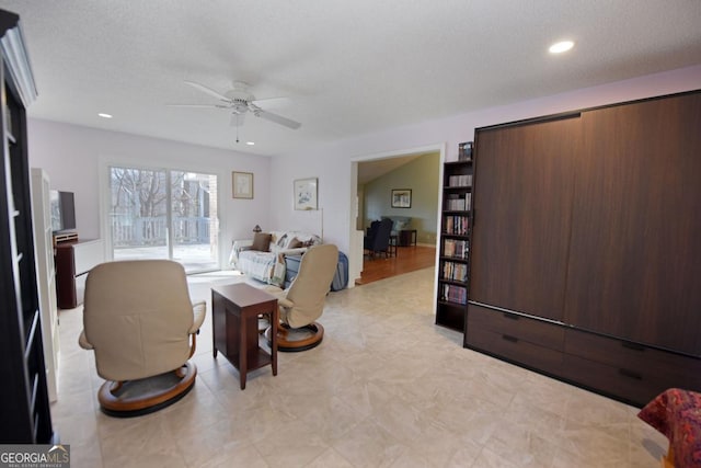 living room featuring a textured ceiling and ceiling fan