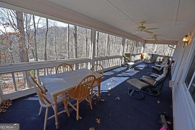 unfurnished sunroom featuring ceiling fan