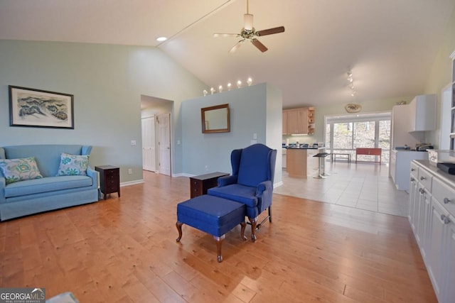 living room featuring ceiling fan, high vaulted ceiling, and light wood-type flooring