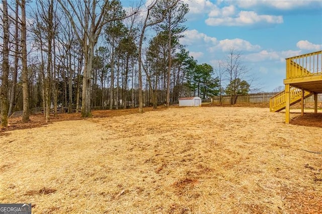 view of yard featuring a shed and a wooden deck