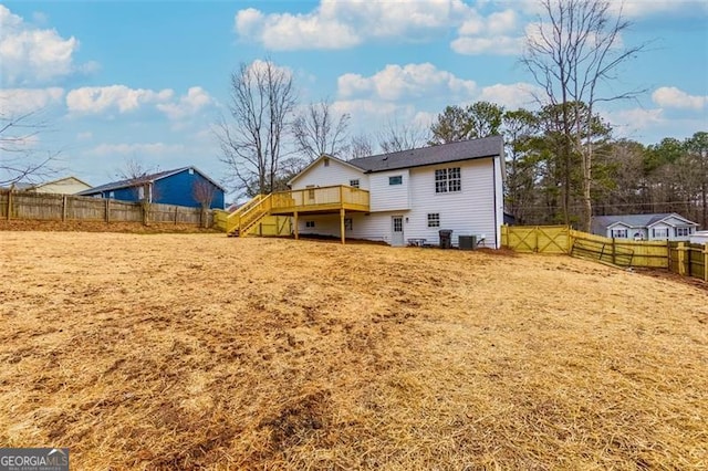 rear view of house featuring a wooden deck and central AC