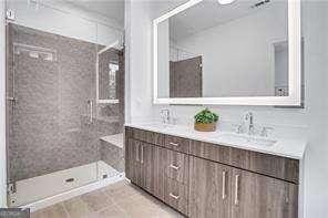 bathroom featuring vanity and a shower with shower door