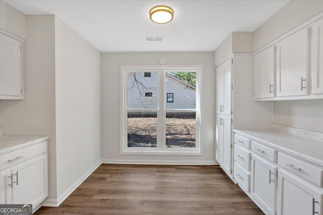 interior space with hardwood / wood-style flooring and white cabinets