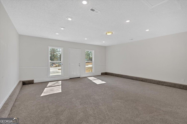 carpeted spare room with a textured ceiling