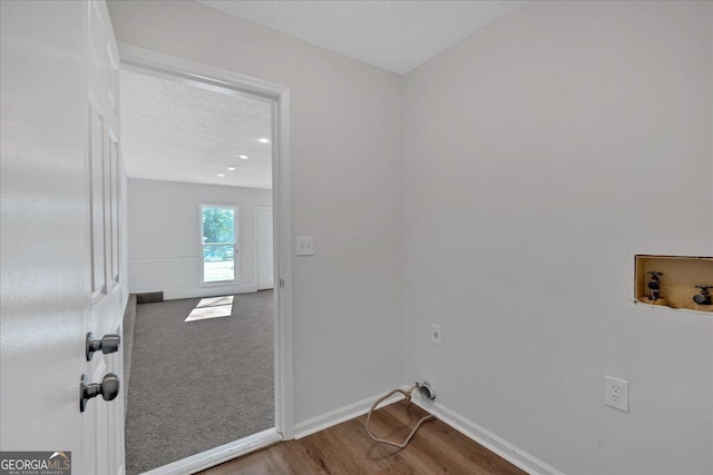 laundry room with hookup for a washing machine, a textured ceiling, and hardwood / wood-style flooring