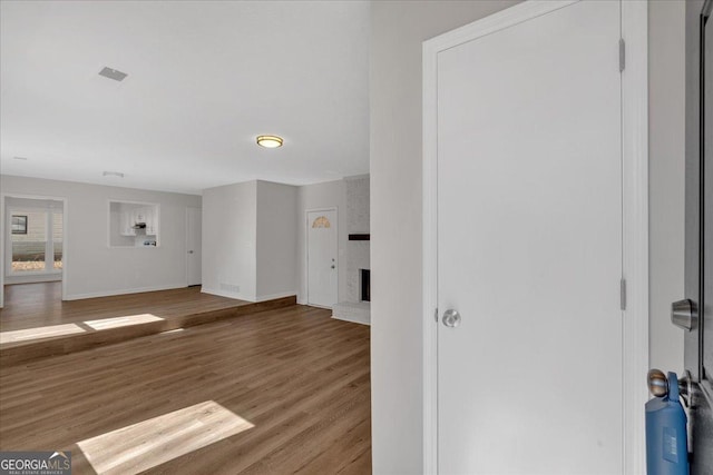 unfurnished living room with hardwood / wood-style floors and a fireplace