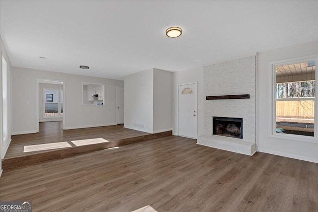 unfurnished living room featuring dark hardwood / wood-style flooring and a fireplace