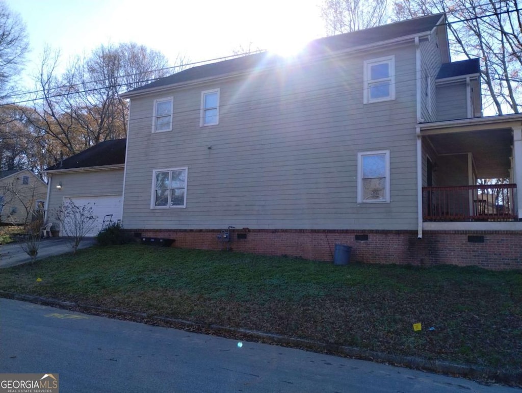 view of side of property with a garage and a lawn