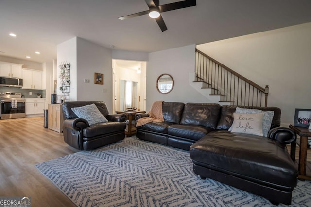 living room featuring light hardwood / wood-style floors and ceiling fan