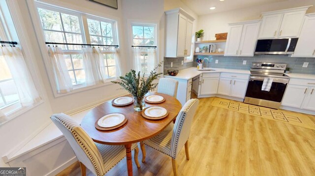 kitchen featuring light wood-type flooring, white cabinets, and appliances with stainless steel finishes