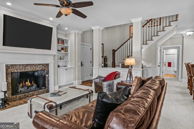 living room featuring ornamental molding, light carpet, ceiling fan, and a high end fireplace