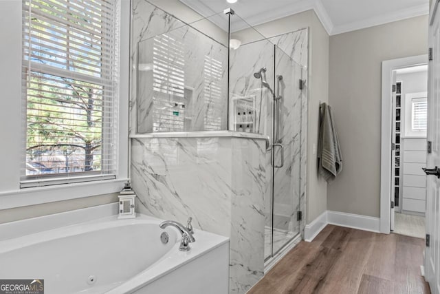 bathroom with plus walk in shower, plenty of natural light, ornamental molding, and wood-type flooring