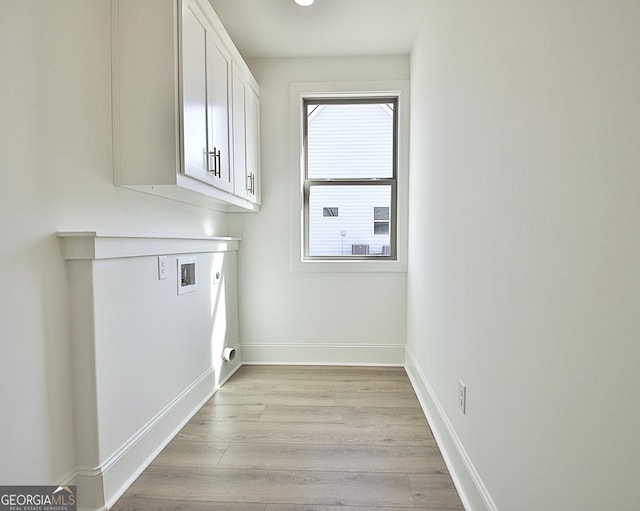 laundry area featuring cabinets, hookup for a washing machine, electric dryer hookup, and light hardwood / wood-style flooring