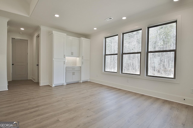 unfurnished living room featuring a healthy amount of sunlight and light wood-type flooring