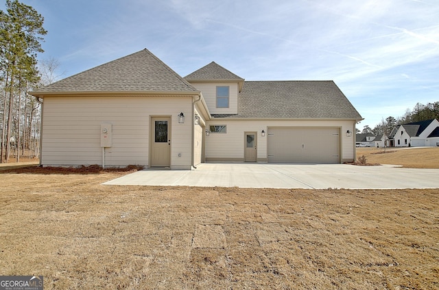 rear view of house with a garage and a yard