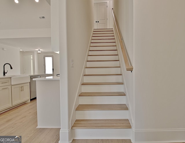 stairs with wood-type flooring and sink