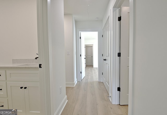 hall featuring sink and light hardwood / wood-style floors