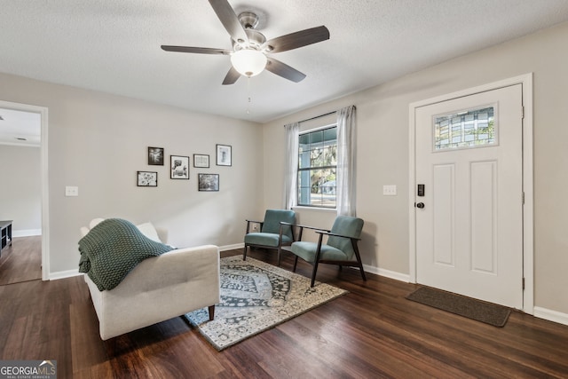 foyer featuring ceiling fan, dark wood-type flooring, and a textured ceiling