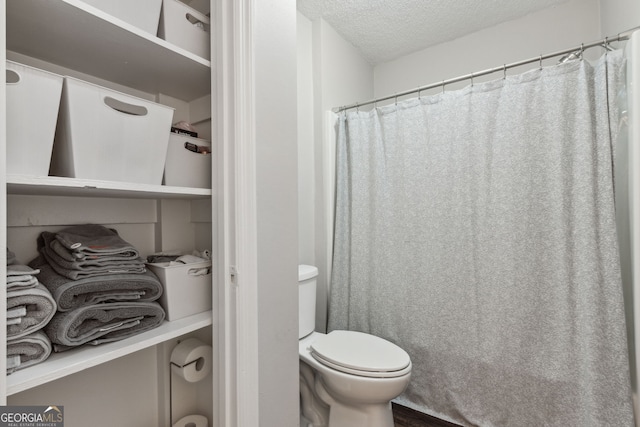 bathroom featuring a textured ceiling and toilet