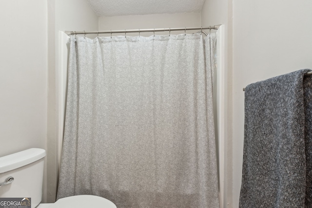 bathroom featuring toilet and a textured ceiling