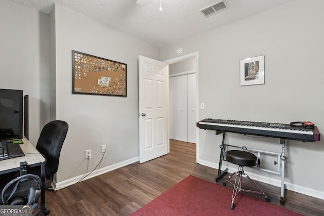 home office featuring dark wood-type flooring and a textured ceiling