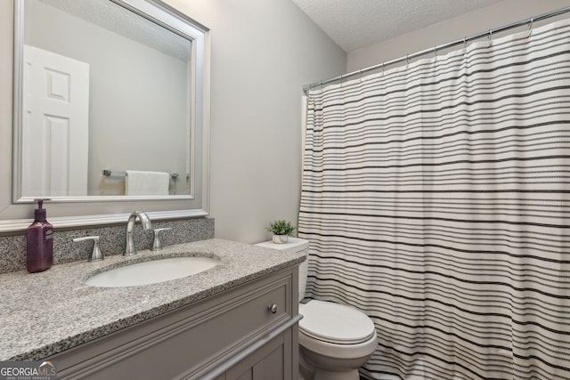 bathroom with vanity, toilet, a textured ceiling, and a shower with shower curtain