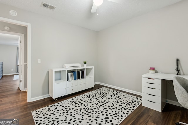 bedroom with ceiling fan, dark wood-type flooring, and a textured ceiling