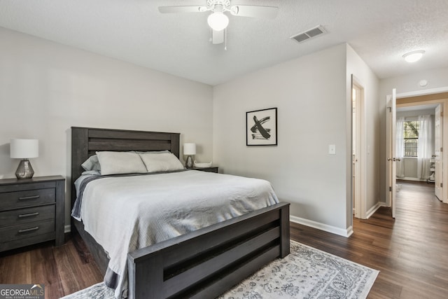 bedroom featuring ceiling fan, a textured ceiling, and dark hardwood / wood-style flooring