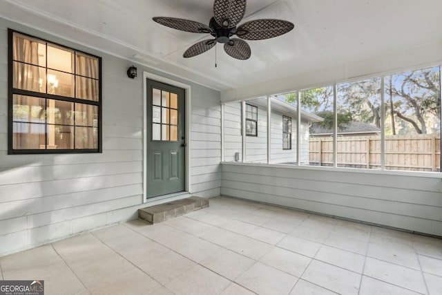 unfurnished sunroom featuring ceiling fan