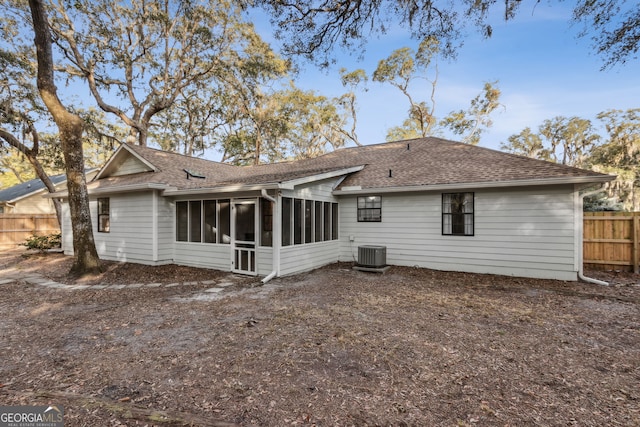 rear view of house with central AC and a sunroom