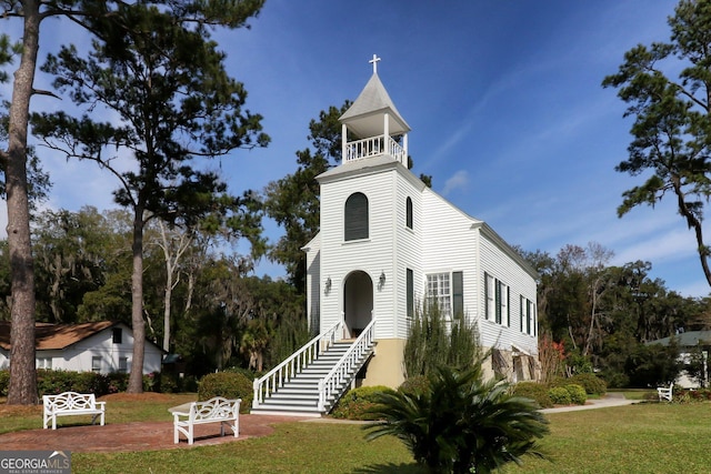 view of front of property with a front lawn and a balcony