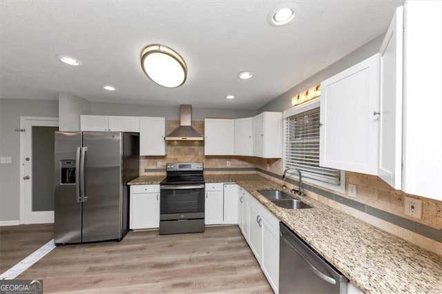 kitchen featuring white cabinetry, appliances with stainless steel finishes, sink, and wall chimney exhaust hood