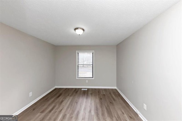 spare room with wood-type flooring and a textured ceiling