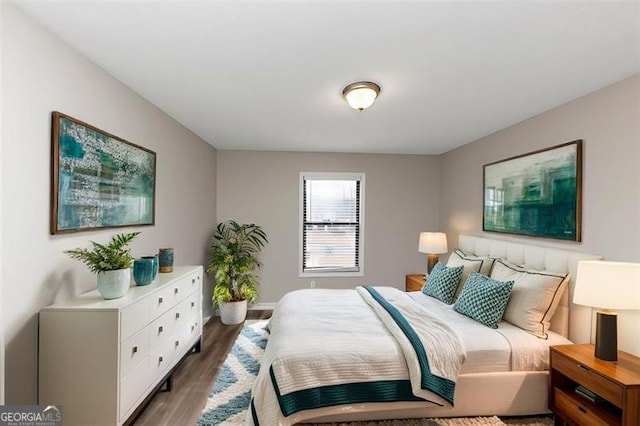 bedroom with dark hardwood / wood-style floors