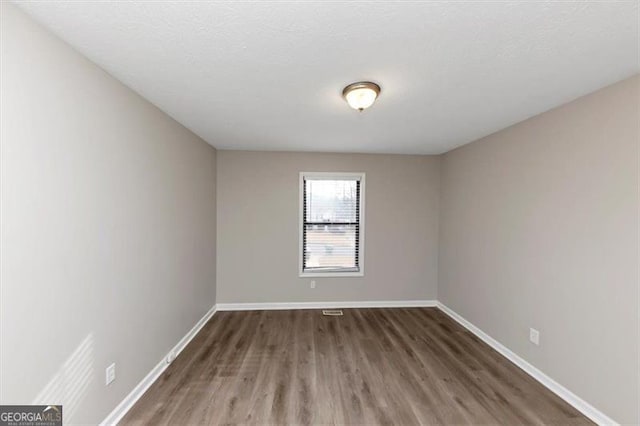 empty room featuring dark hardwood / wood-style flooring