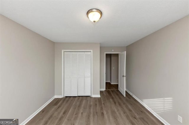 unfurnished bedroom with hardwood / wood-style flooring and a closet