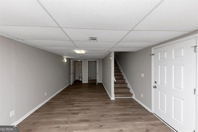 basement with a paneled ceiling and wood-type flooring