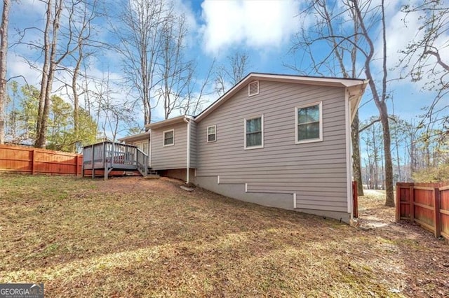 rear view of property featuring a yard and a deck