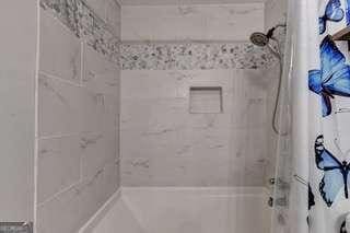 bathroom with tiled shower / bath combo