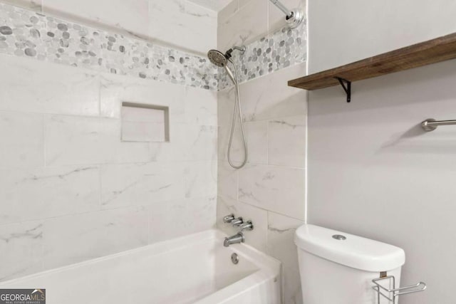 bathroom featuring tiled shower / bath and toilet