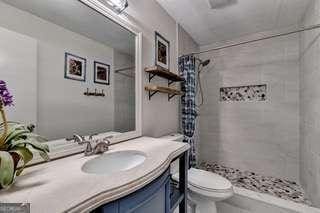 bathroom featuring toilet, vanity, and a shower with shower curtain