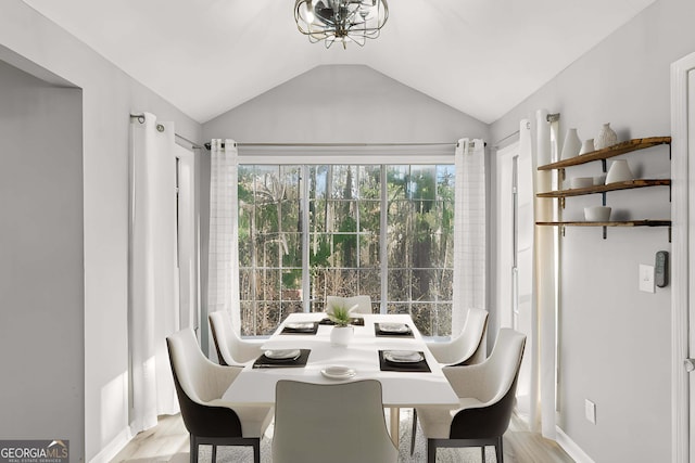 dining space with vaulted ceiling and light hardwood / wood-style floors