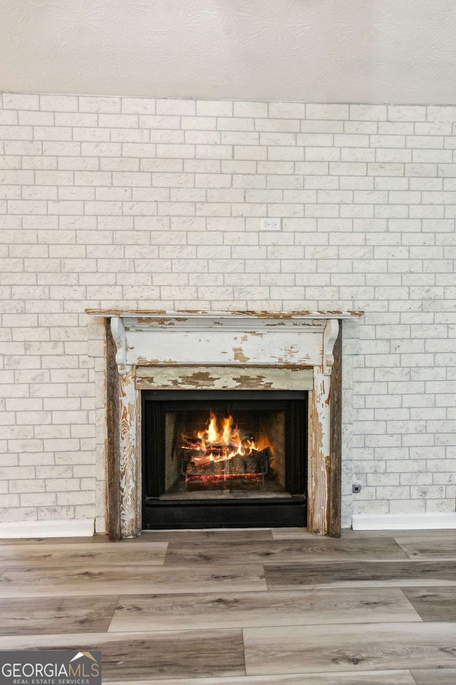 room details with hardwood / wood-style floors, a textured ceiling, and a fireplace