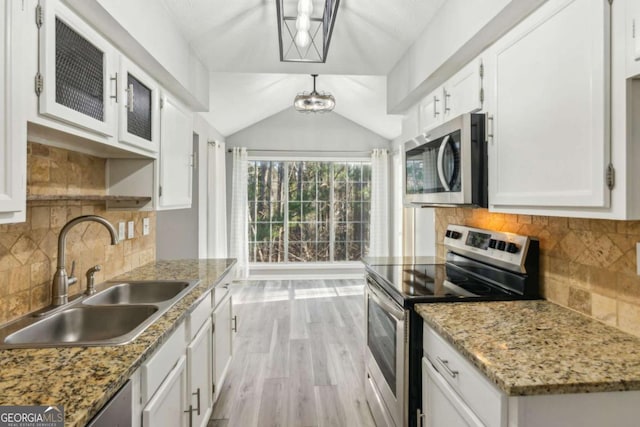 kitchen with stainless steel appliances, white cabinetry, sink, and light stone counters